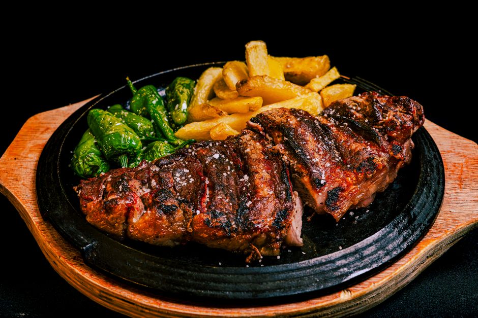 Close-up of professionally plated grilled dish with vegetables and sauce, showing chef-level preparation and artistic presentation